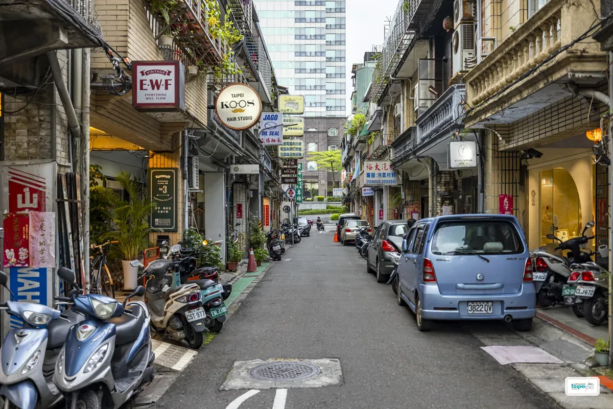 A narrow Chifeng Street side lane lined with hanging boutique signs including a vintage clothing shop and a hair studio